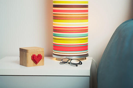 Lovebox sitting next to a pair of glasses on a white counter.